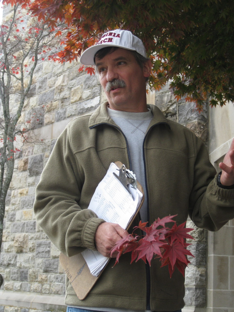John Seiler holding dark red fall leaves