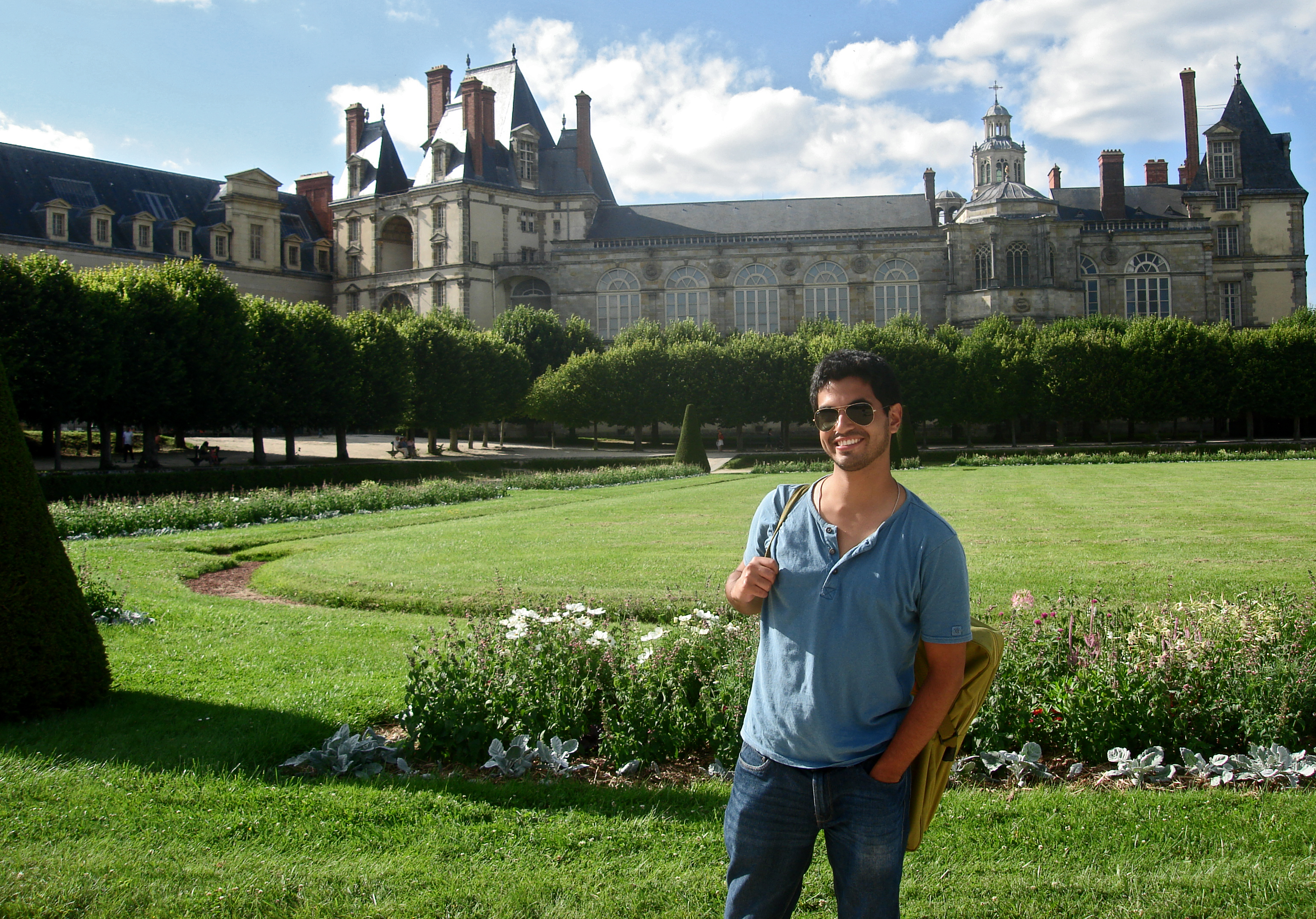Deigo Arias-Caballero standing with the large chateau of Fontainebleau in the background.