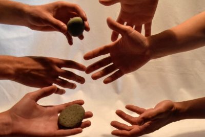 Hands holding and sharing stones