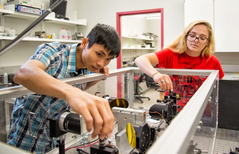Students in physics lab work with lasers