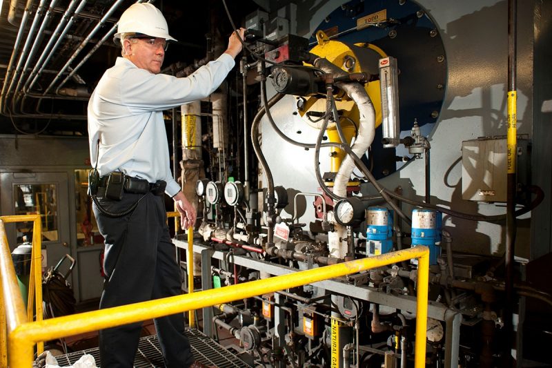 Byron Nichols, senior associate director of utilities in the Facilities Department, working with a boiler in the university's Central Steam Plant.