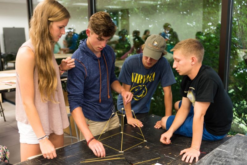 Students building a spaghetti and marshmallow sculpture.