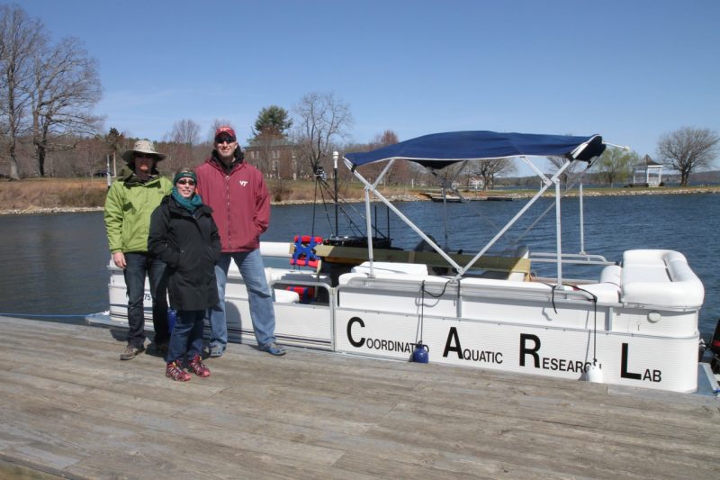 Sample research team stand in front of boat at Claytor Lake