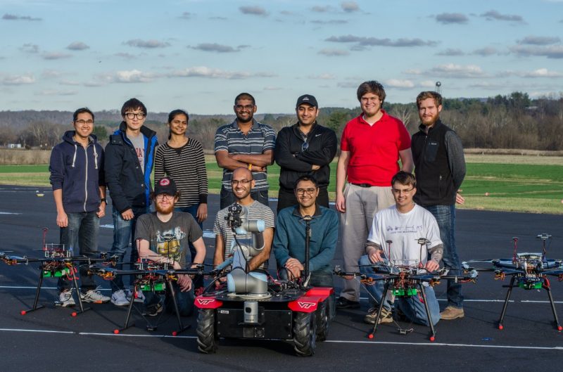 In the posed photo, Team VICTOR stand behind their drones and a ground vehicle.