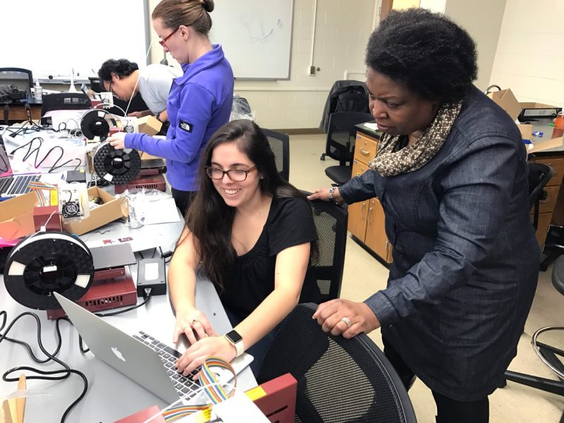 Mary Ann Garifo of Centerville, Virginia, an earth sciences major and student in the Masters in Science Education Program in the School of Education, sets up a 3D printer with help from Associate Professor Brenda Brand, of the School of Education.
