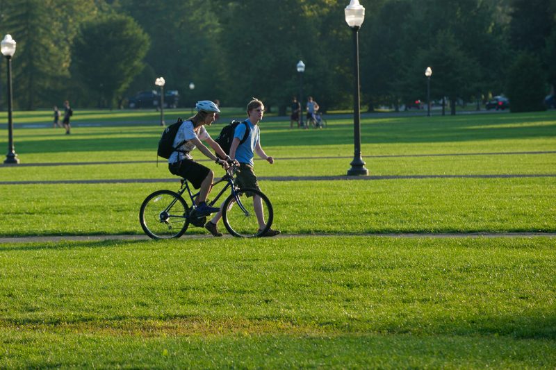 Students cross the Drillfield during a class change in late summer. 