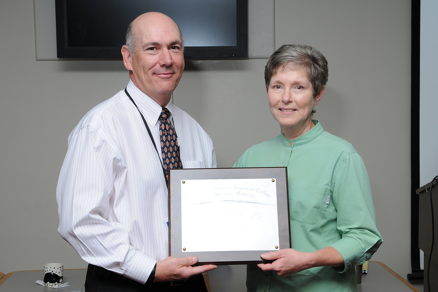 Jenny Robinson (right), fiscal technician, receives the Virginia-Maryland Regional College of Veterinary Medicine's 2009 Veterinary Teaching Hospital Staff Recognition Award from Rick Hiller, hospital administrator.
