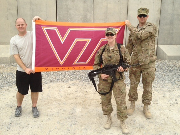 Standing in front of the VT flag is Capt. Kim French, U.S. Air Force, Virginia Tech Corps of Cadets Class of 2005 while on deployment in Afghanistan
