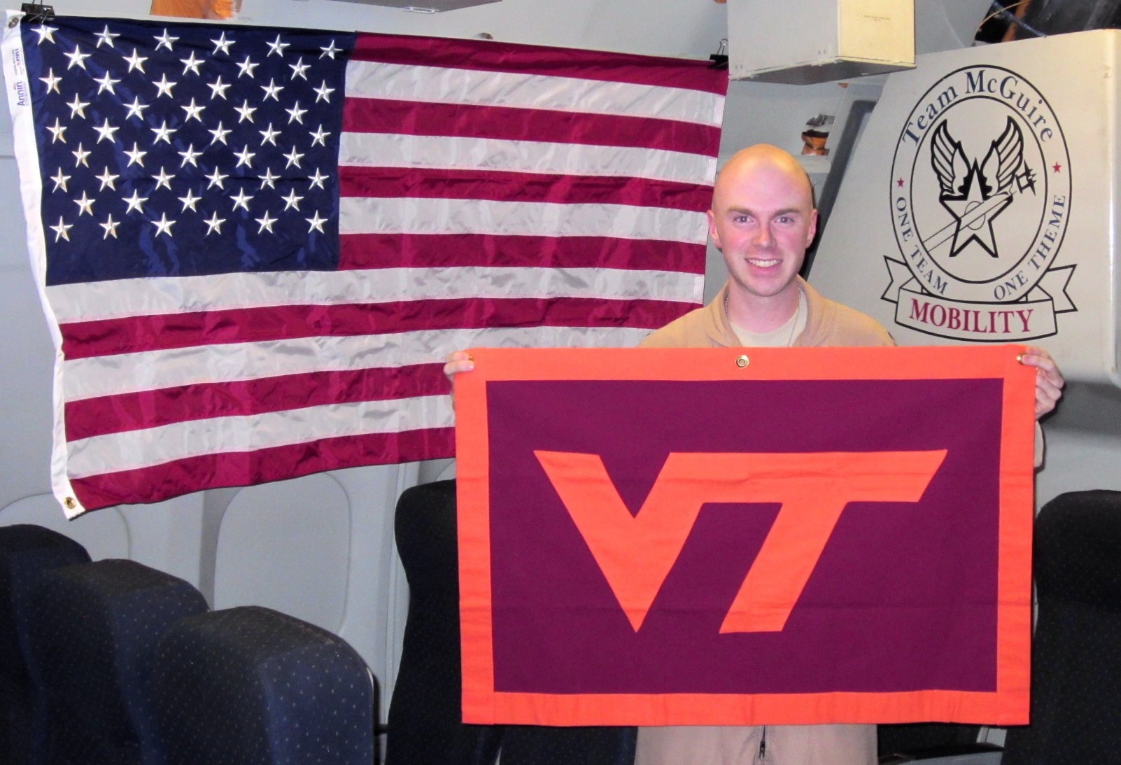 Capt. Mark Amos, U.S. Air Force, Virginia Tech Corps of Cadets Class of 2008 shown inside his aircraft with a VT flag.