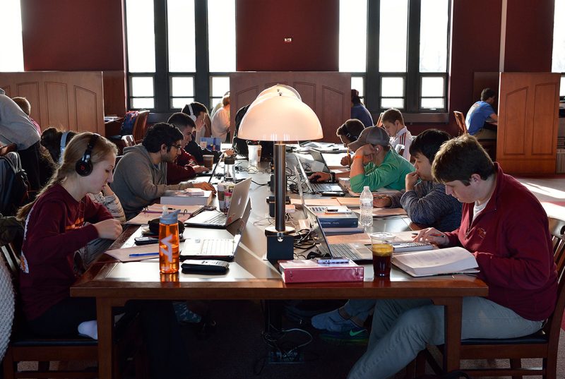 Students studying for finals at a long table in Torgersen Hall
