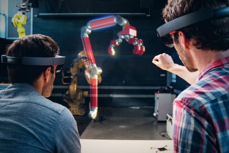 Two users wear the Microsoft HoloLens to interact with a hologram. Image: Microsoft