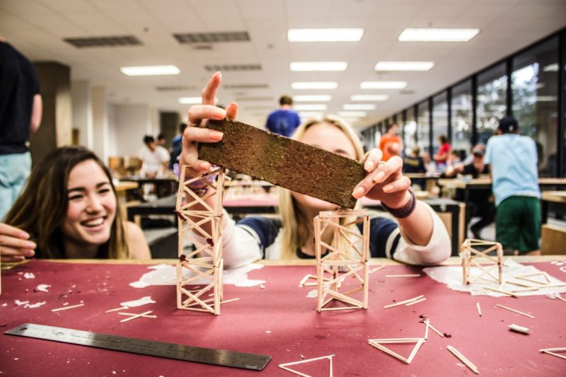 Students building brick challenge structure