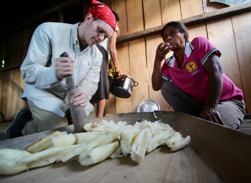 Lester Schonberger helps make chicha, a local drink made by woman who chew up cassava root. 