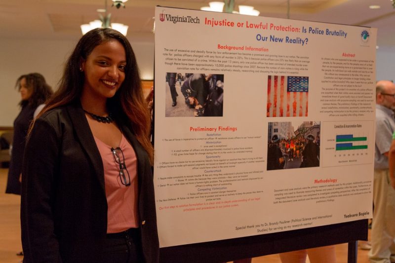 Yeabsera Bogale, a political science major at Virginia Tech, poses for a photo with her summer research poster. 