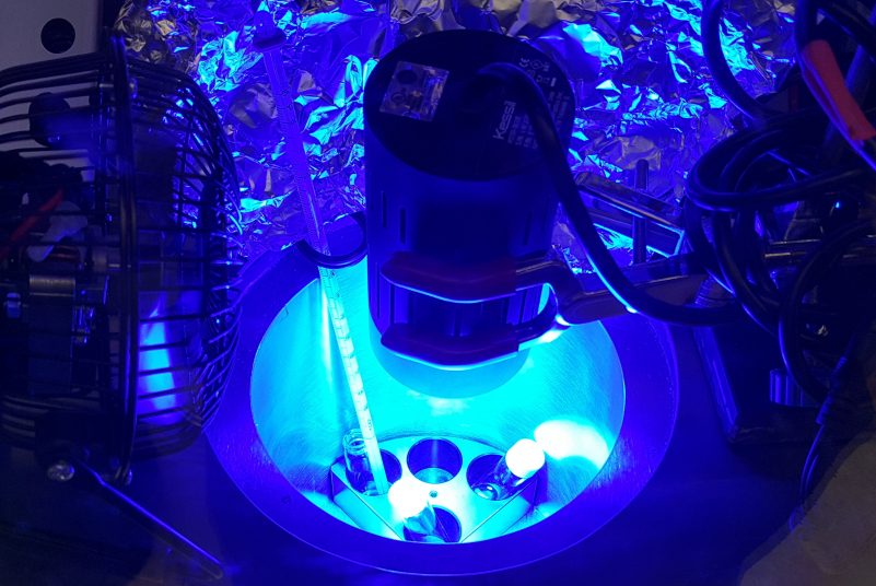 The setup of the photoredox polymerization in the glove box with a cold trap, irradiated by the blue LED light.