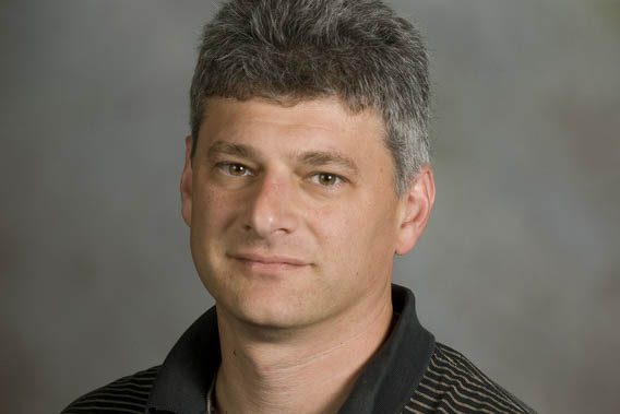 Portrait of Professor Nussbaum wearing a black shirt with stripes 