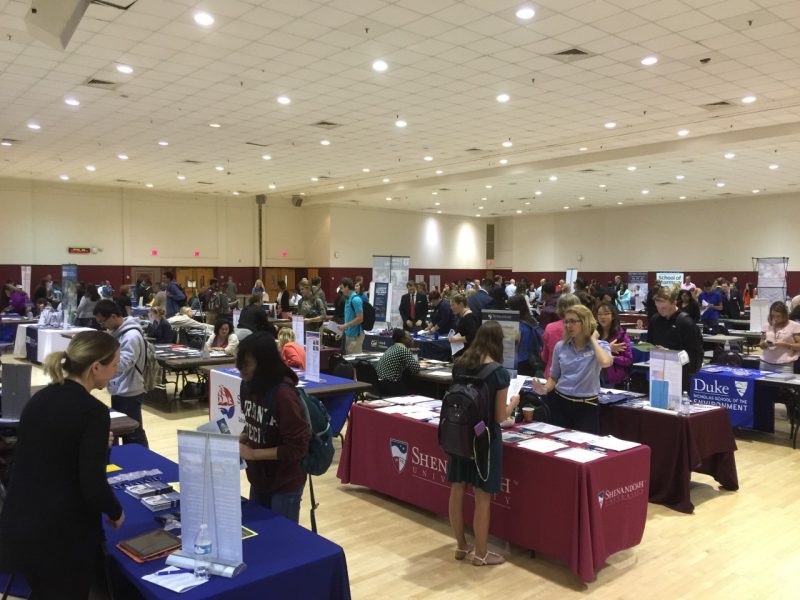 Photo of students talking with representatives of graduate and professional schools at tables in the Commonwealth Ballroom during the 2015 Graduate and Professional School Fair