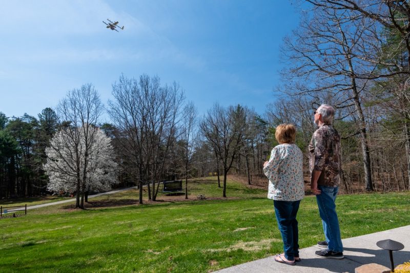 Residents in a Virginia neighborhood watch a drone flying in for a delivery