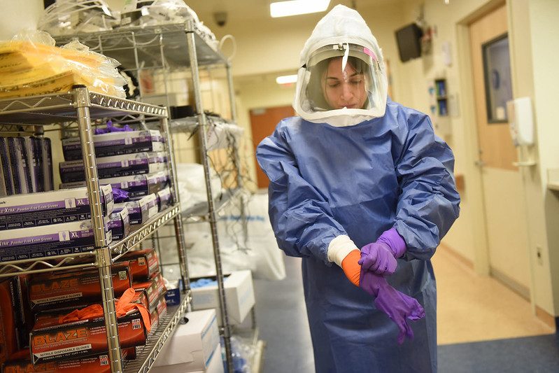 An epidemiologist puts on personal protective equipment (PPE) in a file photo from 2015. Photo courtesy of the National Institutes of Health.