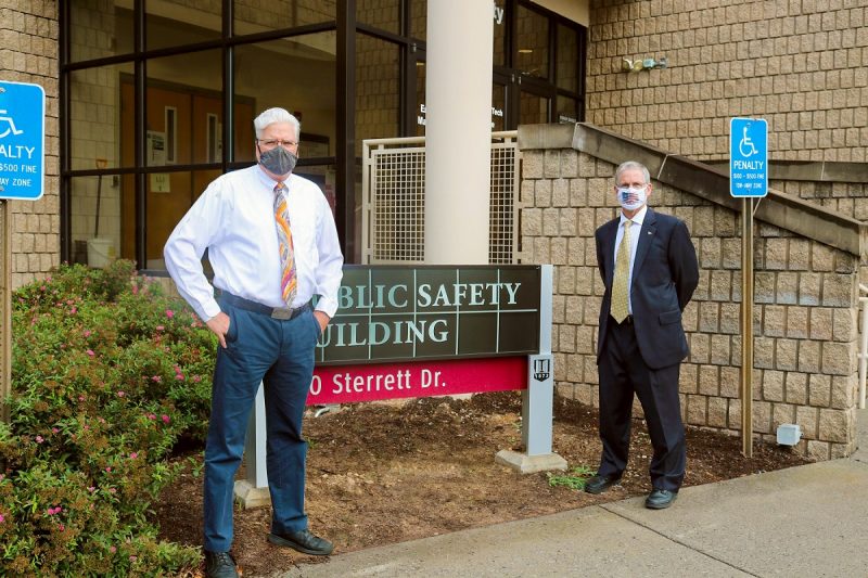 Mike Mulhare (left) and Kevin Foust (right) pose in front of Public Safety Building sign.