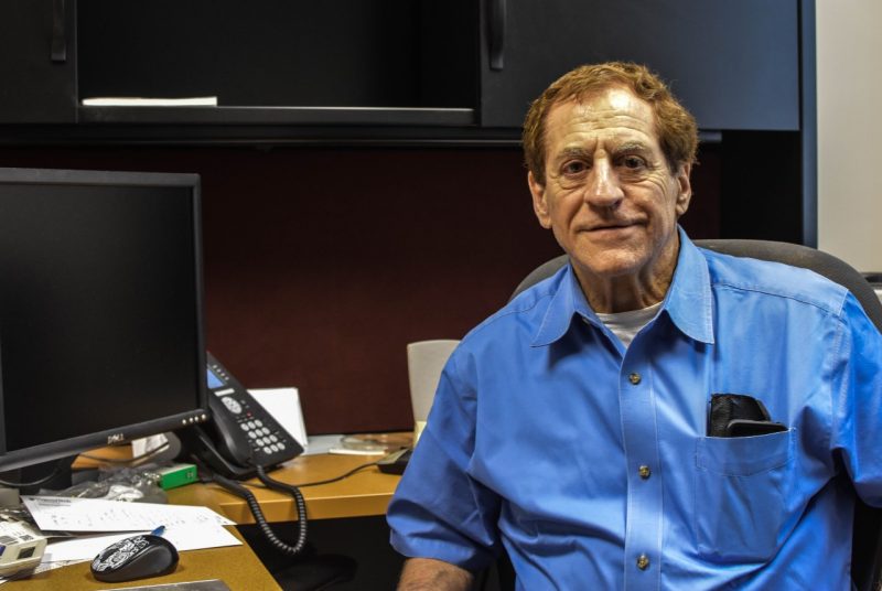 Richard Winett poses in a blue shirt at his office in 2017. 