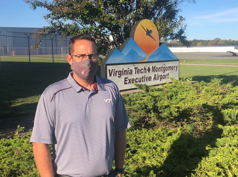 Keith Holt, leaders of the VT Montgomery Executive Airport in front of airport sign.