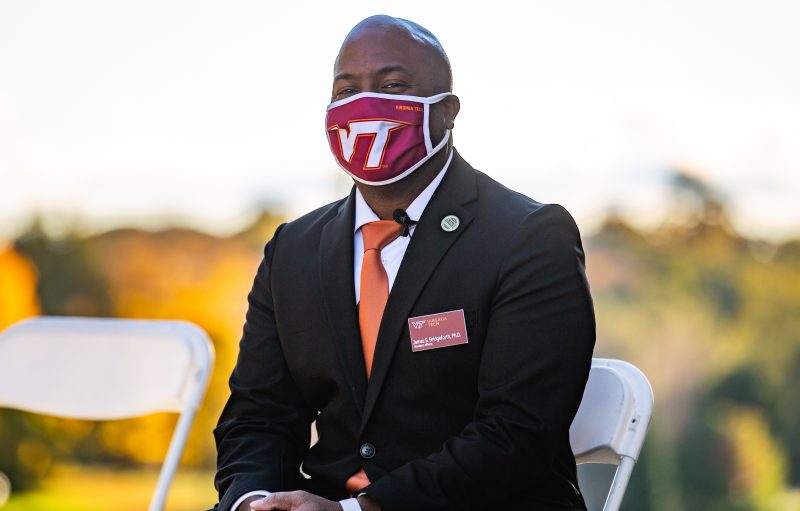 Dr. Bridgeforth sits in a chair wearing a Virginia Tech mask