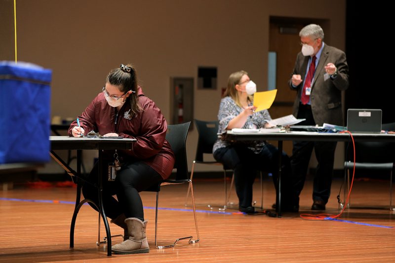 A voter fills out a ballot