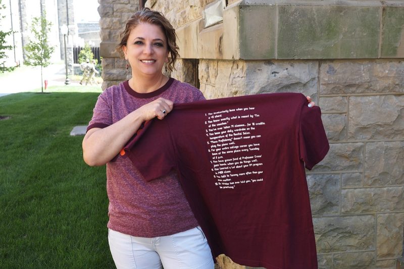 Tammy Henderson holds up a maroon t-shirt with white lettering
