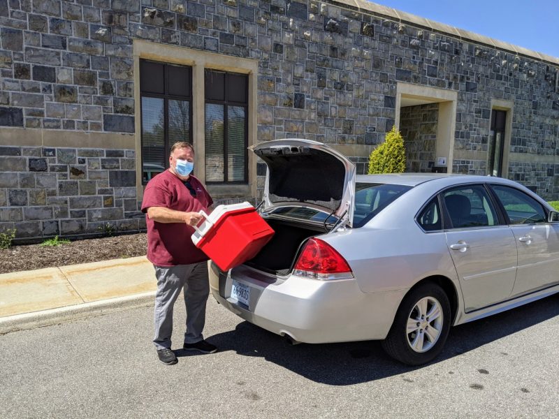 Person loading cooler into car