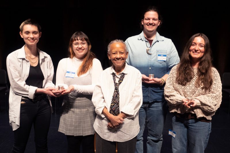 Nikki Giovanni stands with four student finalists in poetry competition. 